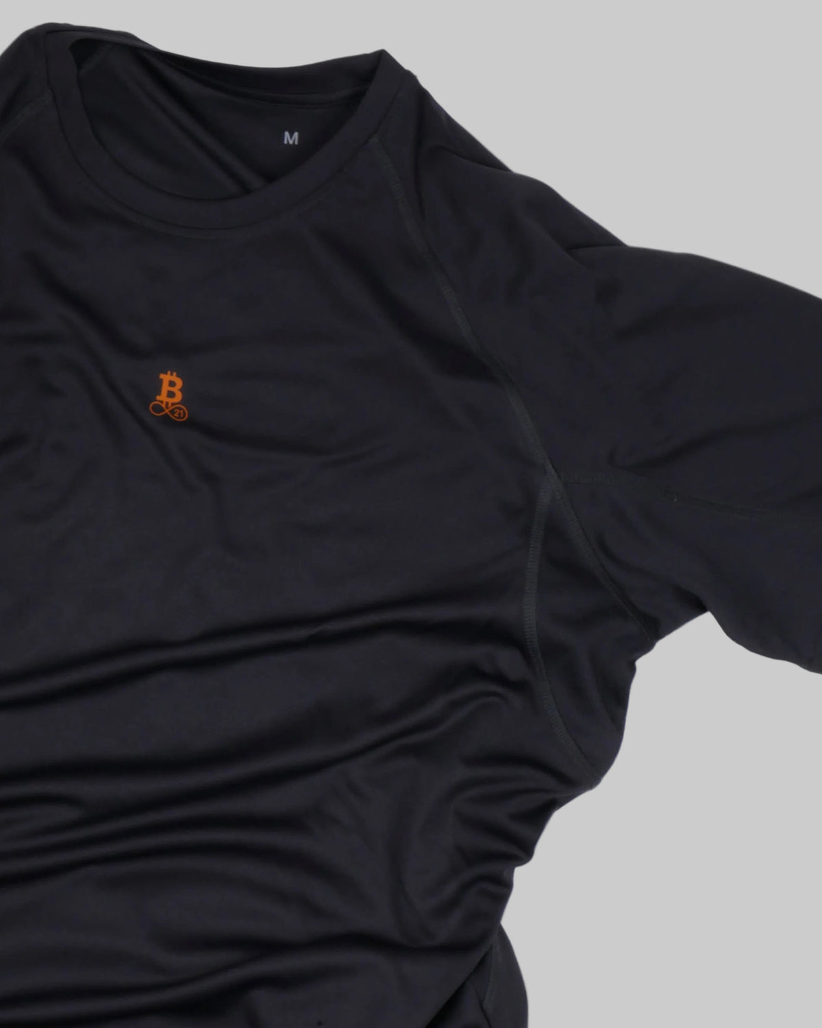 Bitcoin Running Shirt Hal Finney in Charcoal, close-up of the front with the small orange Bitcoin21 logo and the raglan sleeve