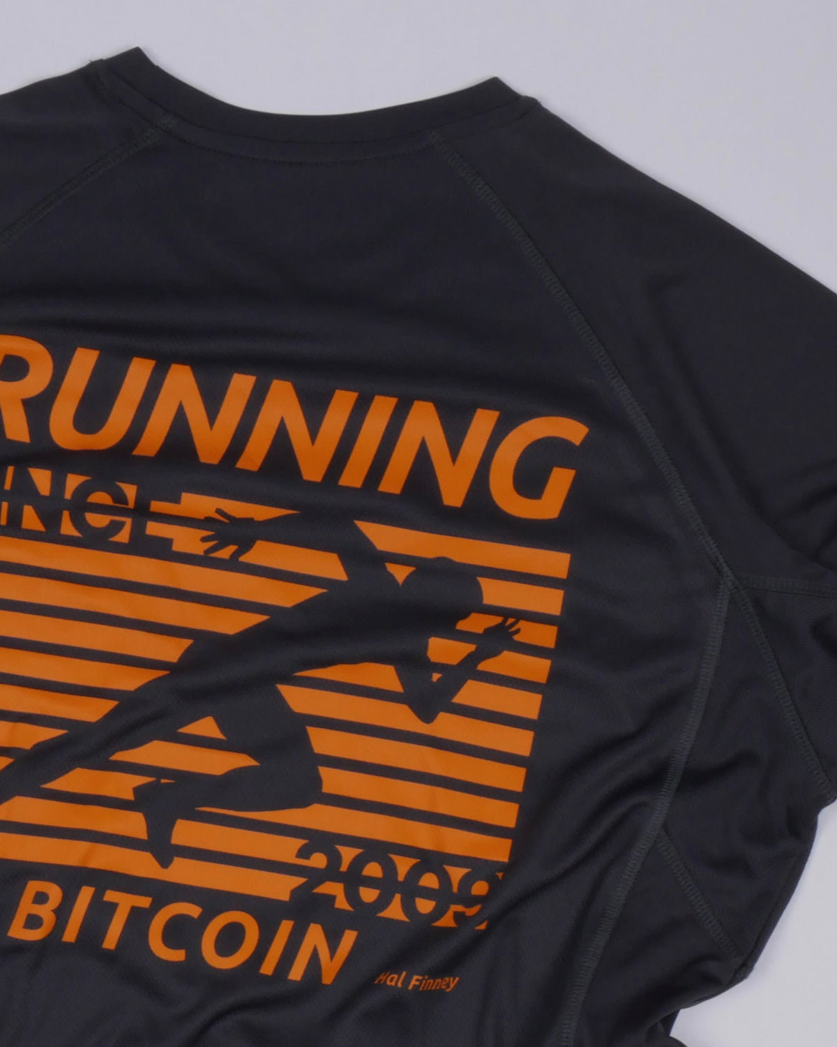 Bitcoin Running Shirt Hal Finney in Charcoal, close-up of the back print with an orange runner, RUNNING BITCOIN, 2009 and Hal Finney