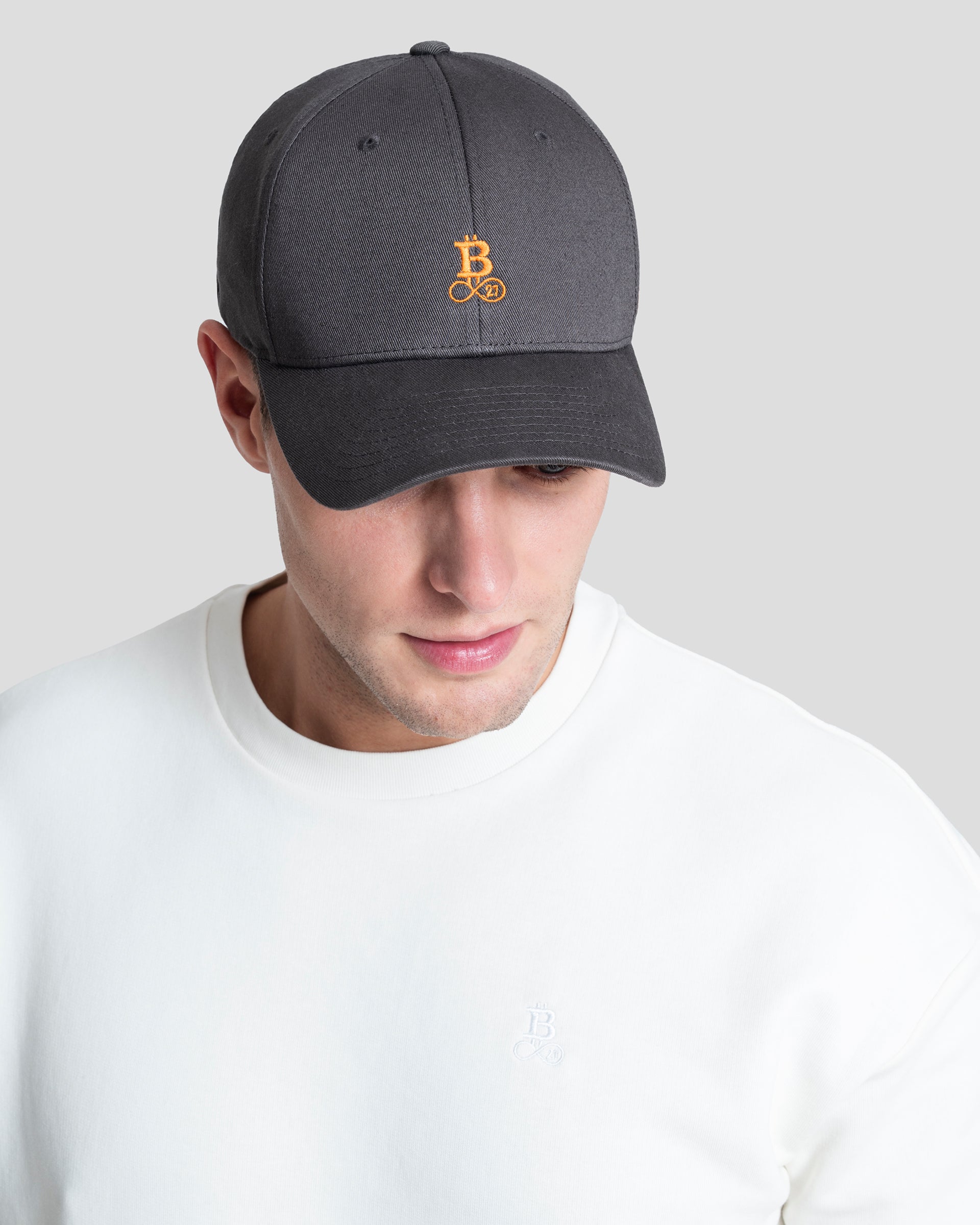 Bitcoin Cap grau aus Bio Baumwolle mit orangefarbenem Bitcoin21 Logo, Snapback Cap in Einheitsgröße am Model getragen