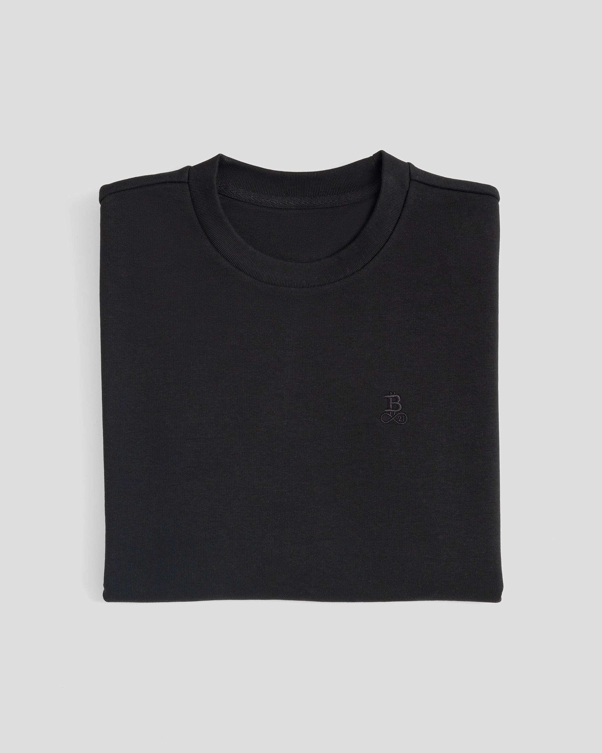 Bitcoin Oversized T-Shirt Privacy - Black für Herren aus schwerer Bio Baumwolle mit ton in ton gesticktem Bitcoin21 Logo, zusammengefaltetes T Shirt vor hellem Hintergrund