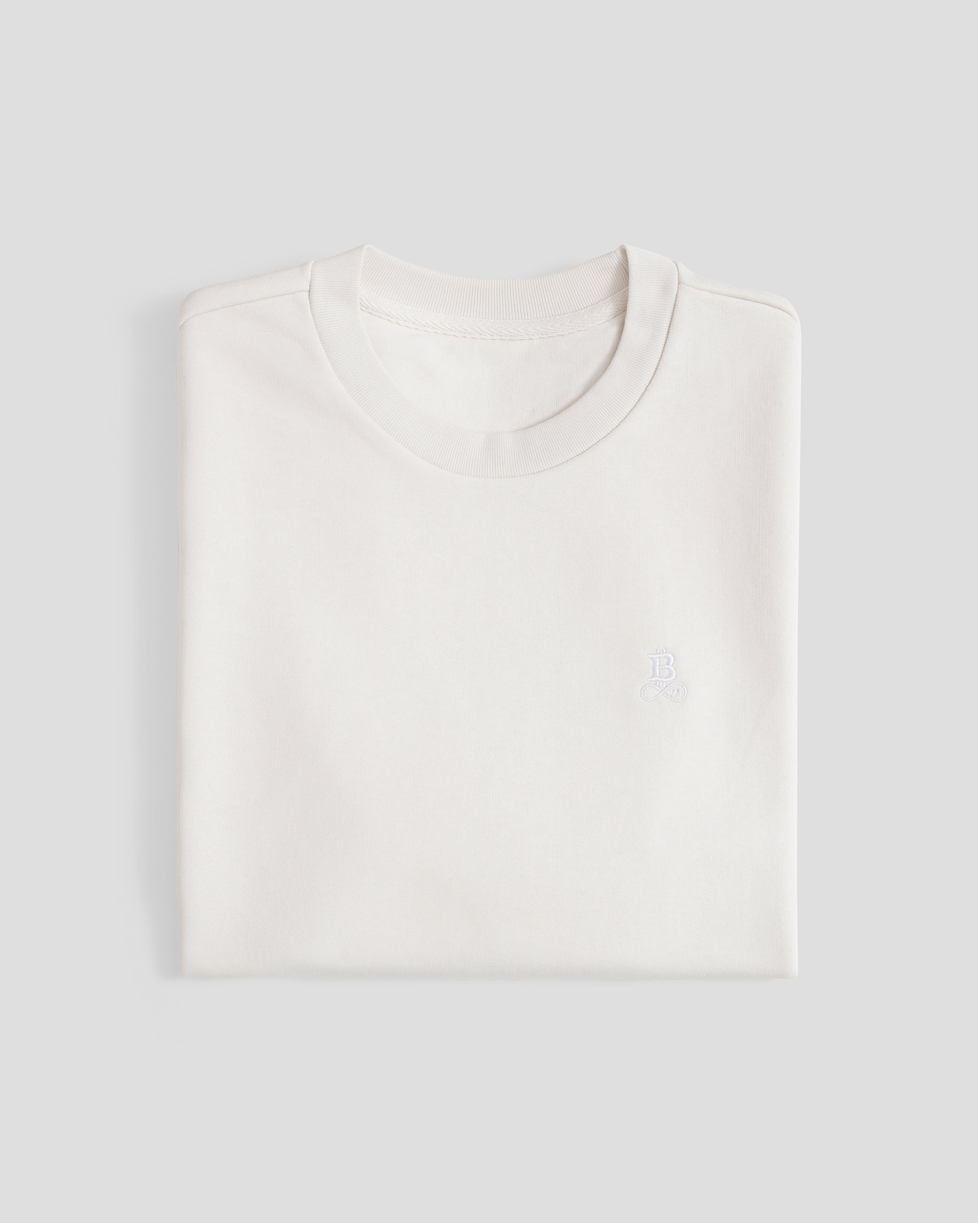 Bitcoin Oversized T-Shirt Privacy - Off-White für Herren aus schwerer Bio Baumwolle mit ton in ton gesticktem Bitcoin21 Logo, zusammengefaltetes T Shirt vor hellem Hintergrund