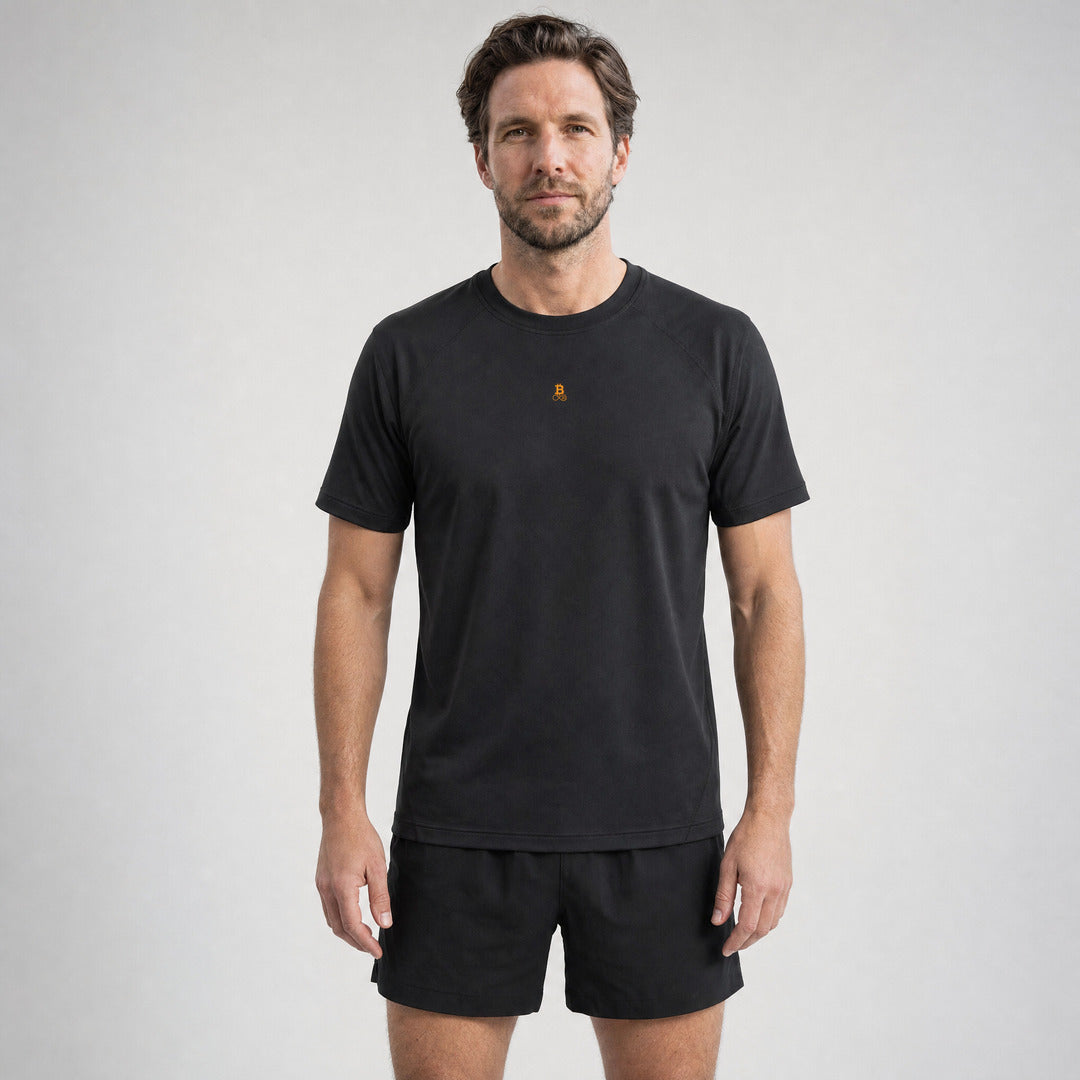 Mann trägt das Bitcoin Laufshirt Running Bitcoin in Schwarz — Vorderseite mit kleinem orangem Bitcoin21-Logo