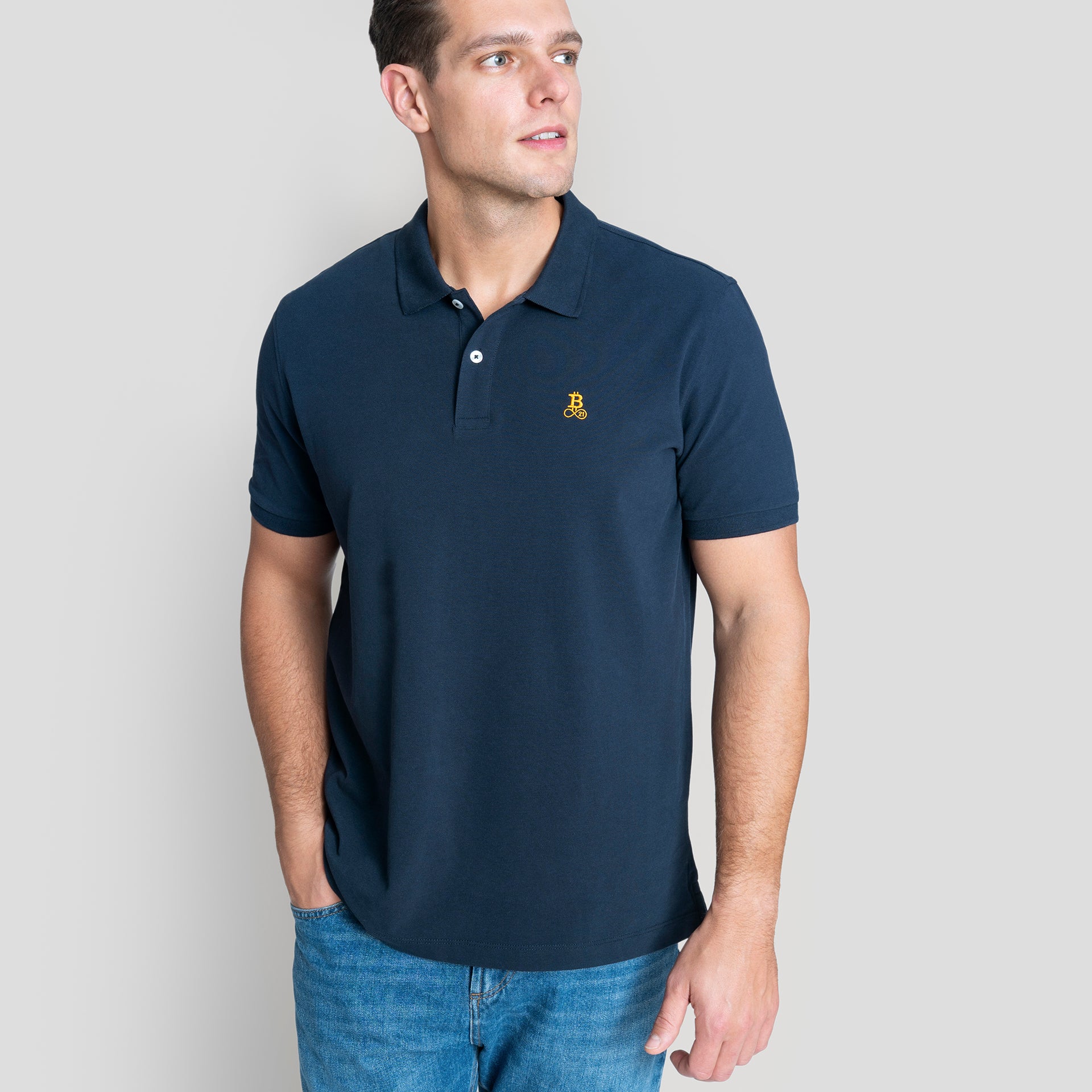 Bitcoin Poloshirt navy für Herren aus Bio Baumwolle mit orangefarbenem Bitcoin21 Logo auf der Brust, normale Passform, Model 1,90 m trägt Größe XL