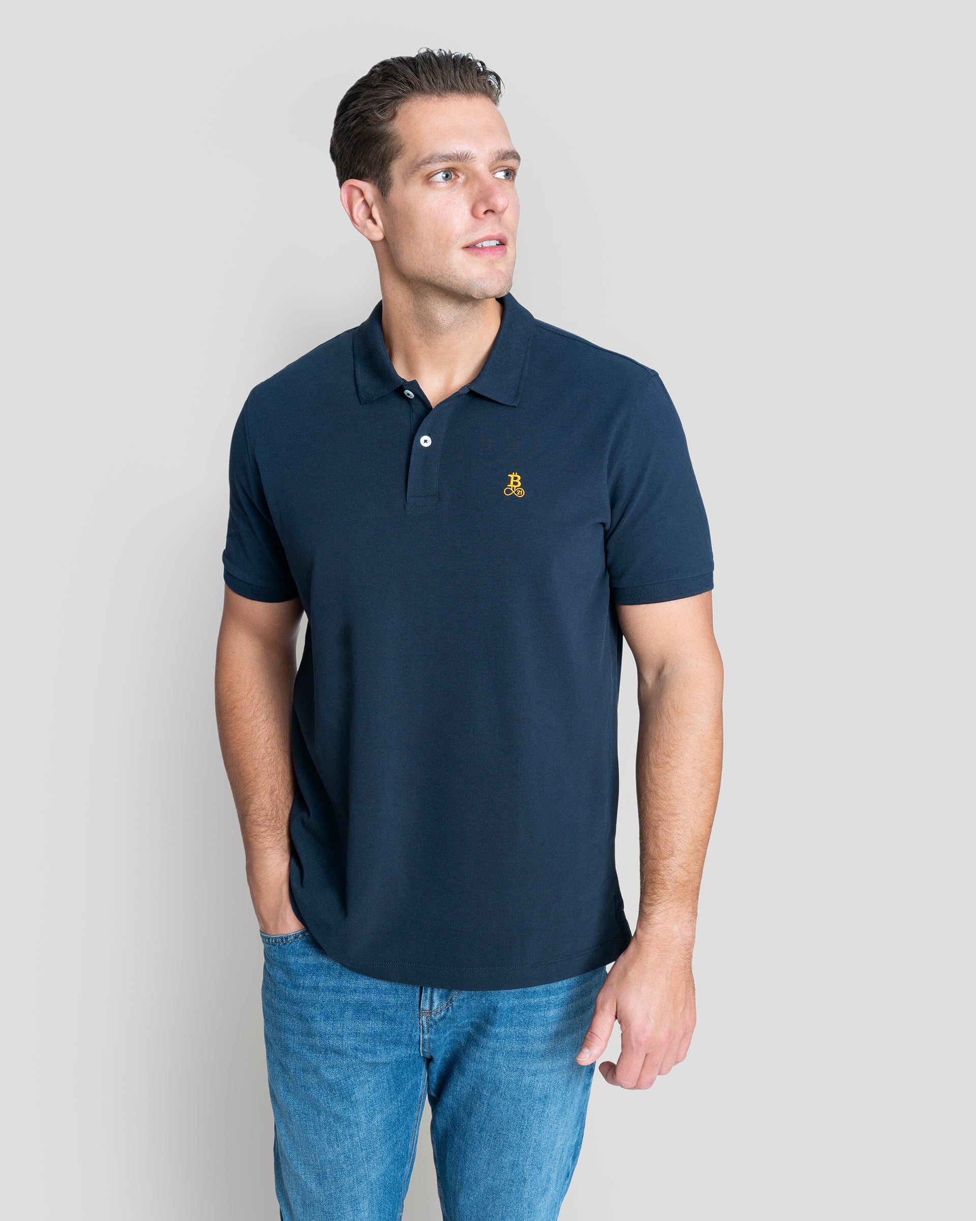 Bitcoin Poloshirt navy für Herren aus Bio Baumwolle mit orangefarbenem Bitcoin21 Logo auf der Brust, normale Passform, Model 1,90 m trägt Größe XL