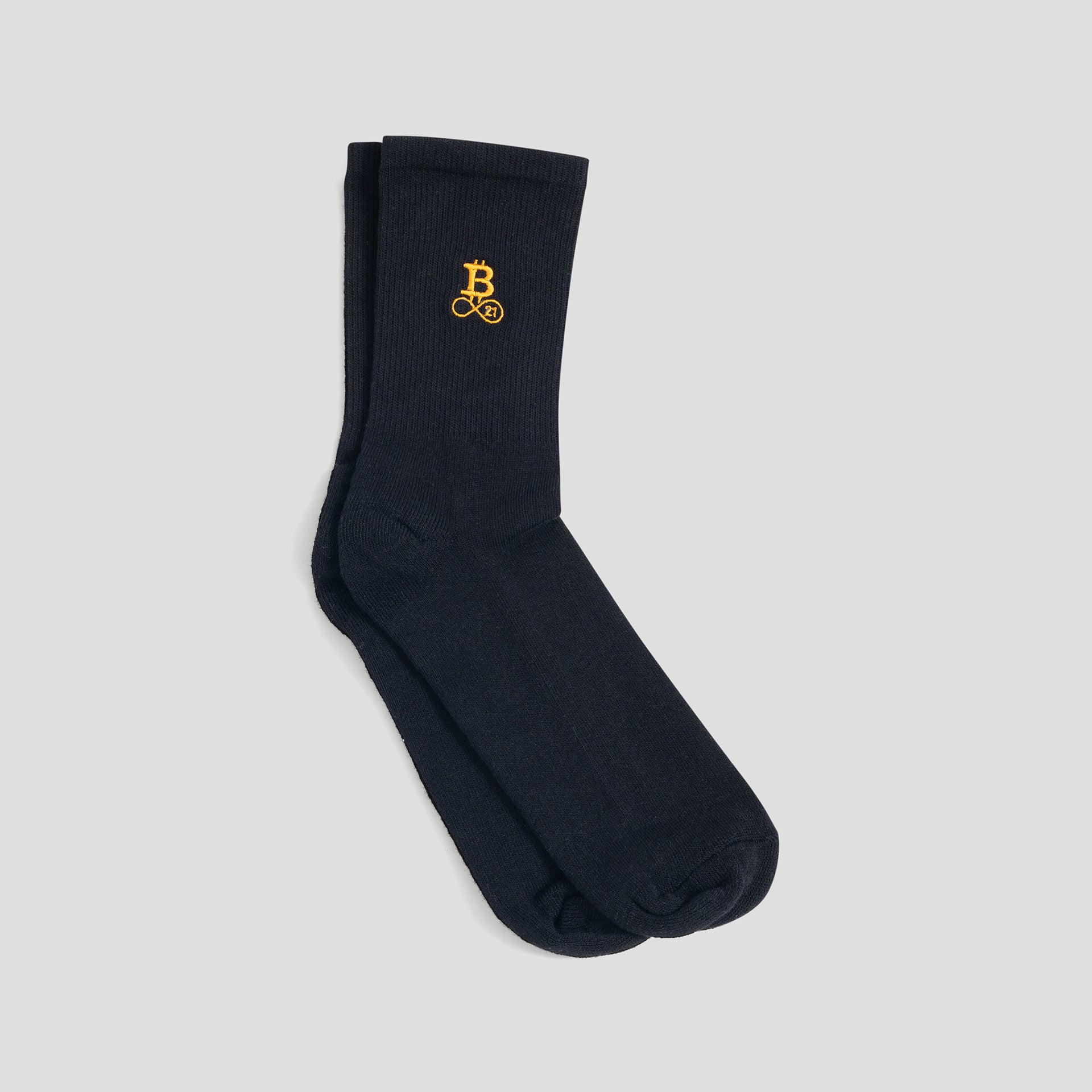 tcoin Socken schwarz mit orangefarbenem Bitcoin21 Logo auf dem Schaft, klassisches Paar Crew Socken freigestellt vor hellem Hintergrund