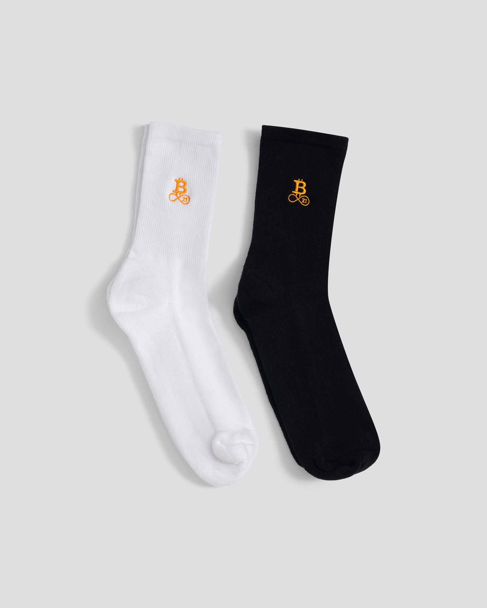Bitcoin Socken im Doppelpack in Weiß und Schwarz mit orangefarbenem Bitcoin21 Logo auf dem Schaft, klassische Crew Socken freigestellt vor hellem Hintergrund