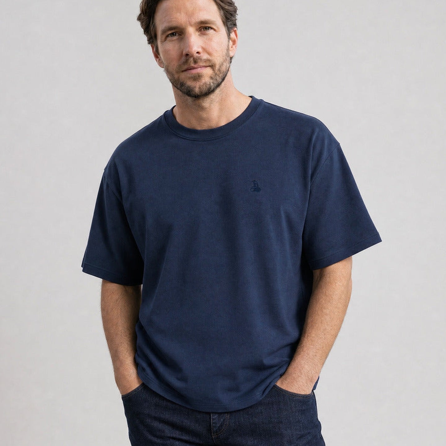 Hombre con la Camiseta oversize Bitcoin Privacy - Azul marino — logo Bitcoin21 bordado tono sobre tono en el pecho, manos en los bolsillos