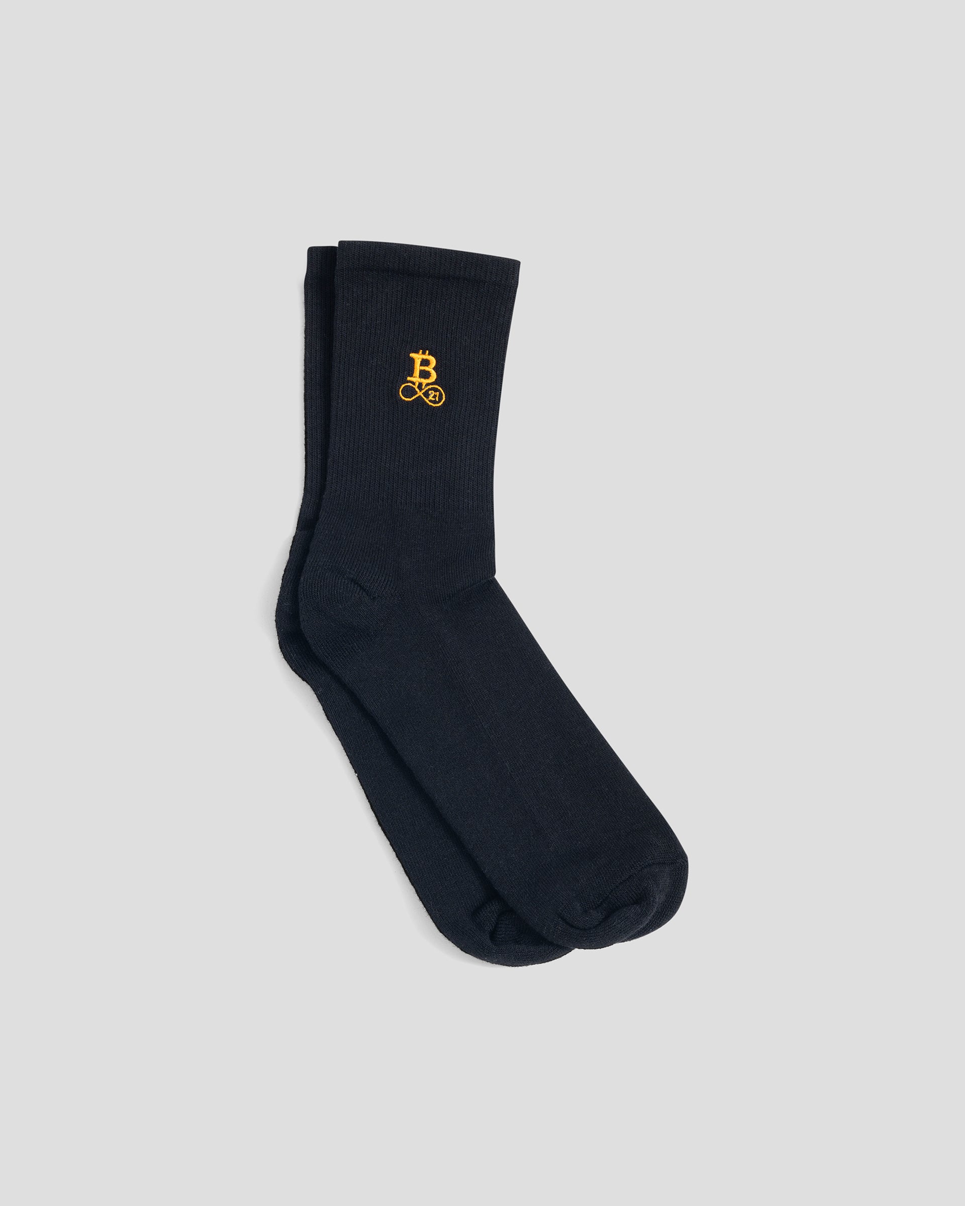 Bitcoin Socken schwarz mit orangefarbenem Bitcoin21 Logo auf dem Schaft, klassisches Paar Crew Socken freigestellt vor hellem Hintergrund