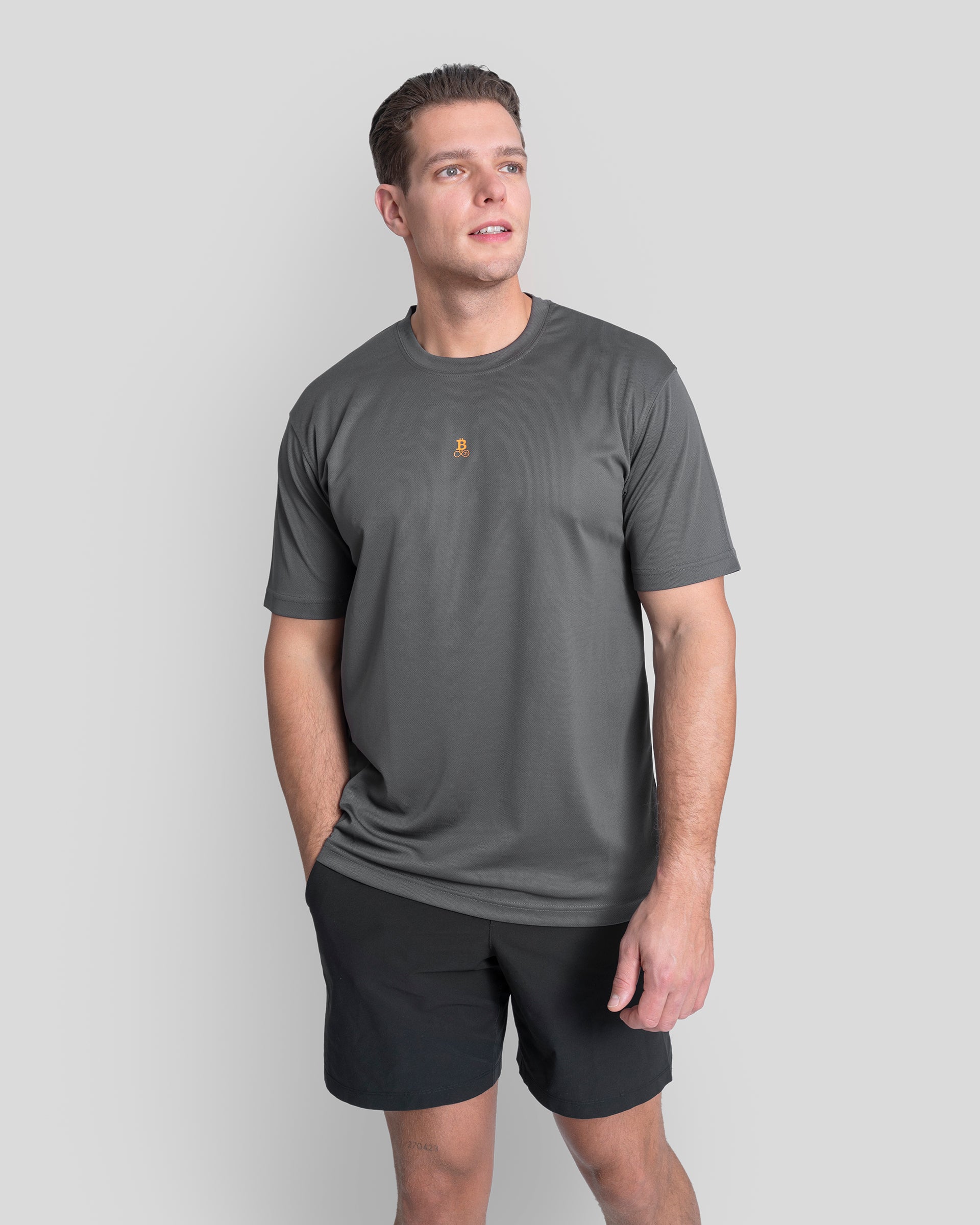 Bitcoin Sportshirt grau für Herren mit orangefarbenem Bitcoin21 Logo, atmungsaktives Funktionsshirt aus 100 % Polyester, Model 1,90 m trägt Größe XL