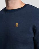Bitcoin Sweatshirt navy für Herren aus schwerem Bio Baumwollmix, Nahaufnahme des gestickten orangefarbenen Bitcoin21 Logos auf der Brust