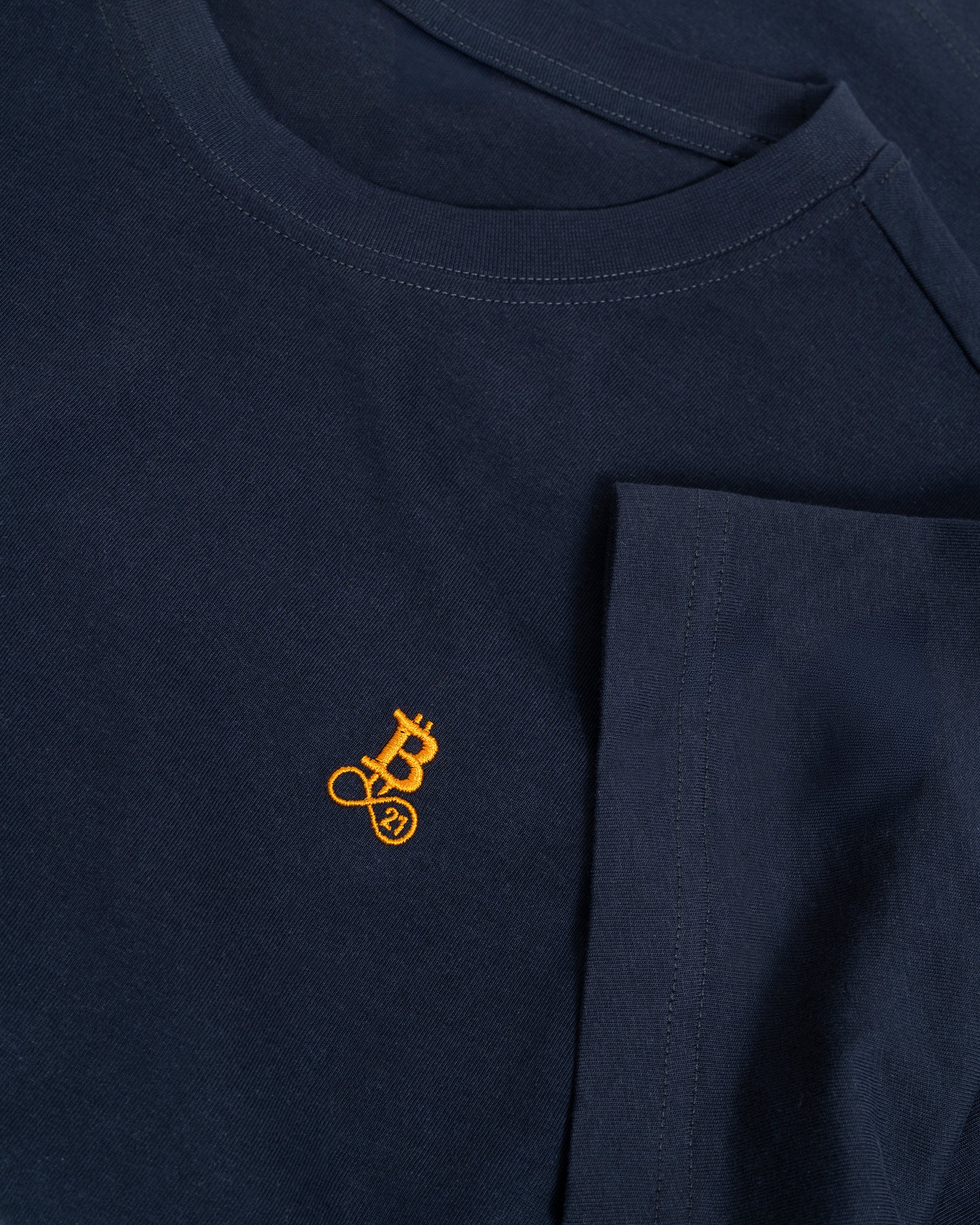 Bitcoin Basic T-Shirt navy mit gesticktem orangefarbenen Bitcoin21 Logo, Detailaufnahme von Rundhalsausschnitt und weicher Baumwollstruktur