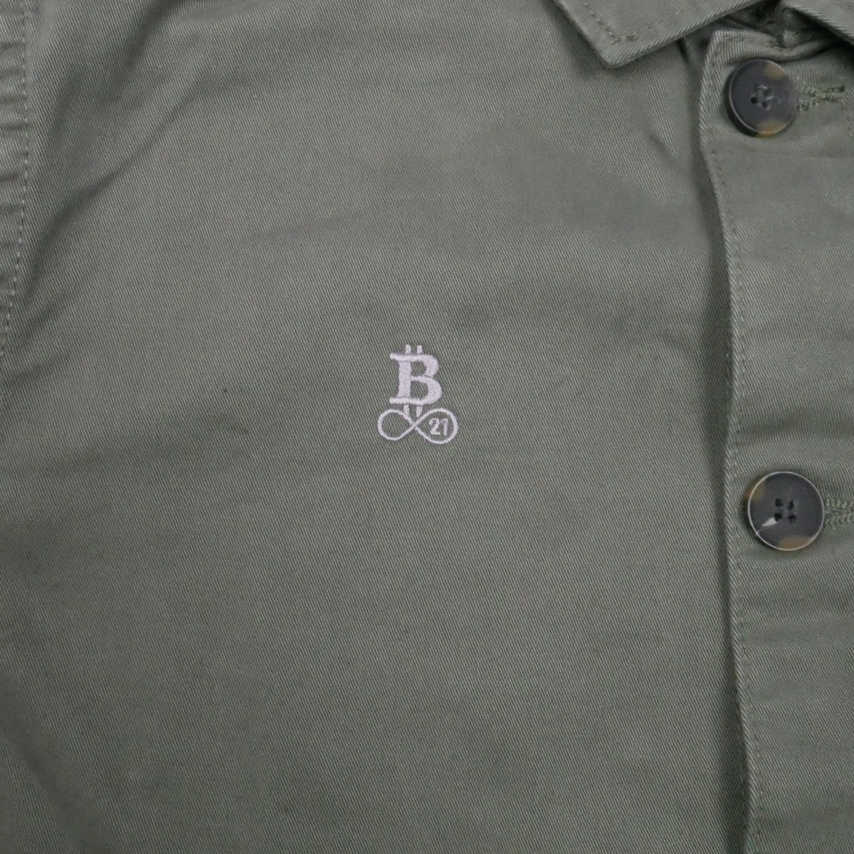 Bitcoin Worker Jacket Privacy in Washed Organic Khaki, Nahaufnahme des Ton in Ton gestickten Bitcoin21-Logos