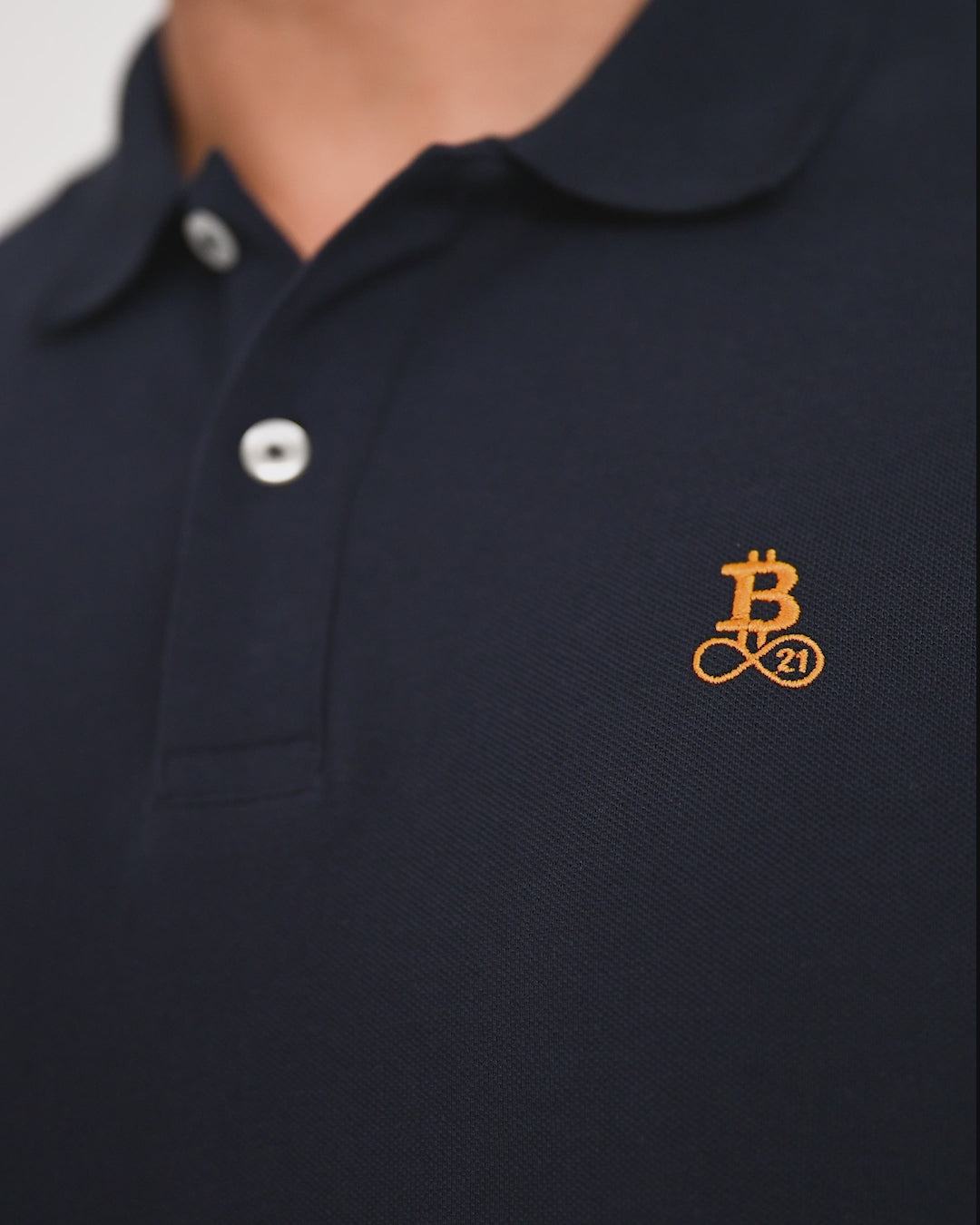 Bitcoin Poloshirt navy für Herren aus Bio Baumwolle mit orangefarbenem Bitcoin21 Logo, Tragevideo mit Model zur Darstellung der normalen Passform und Bewegung